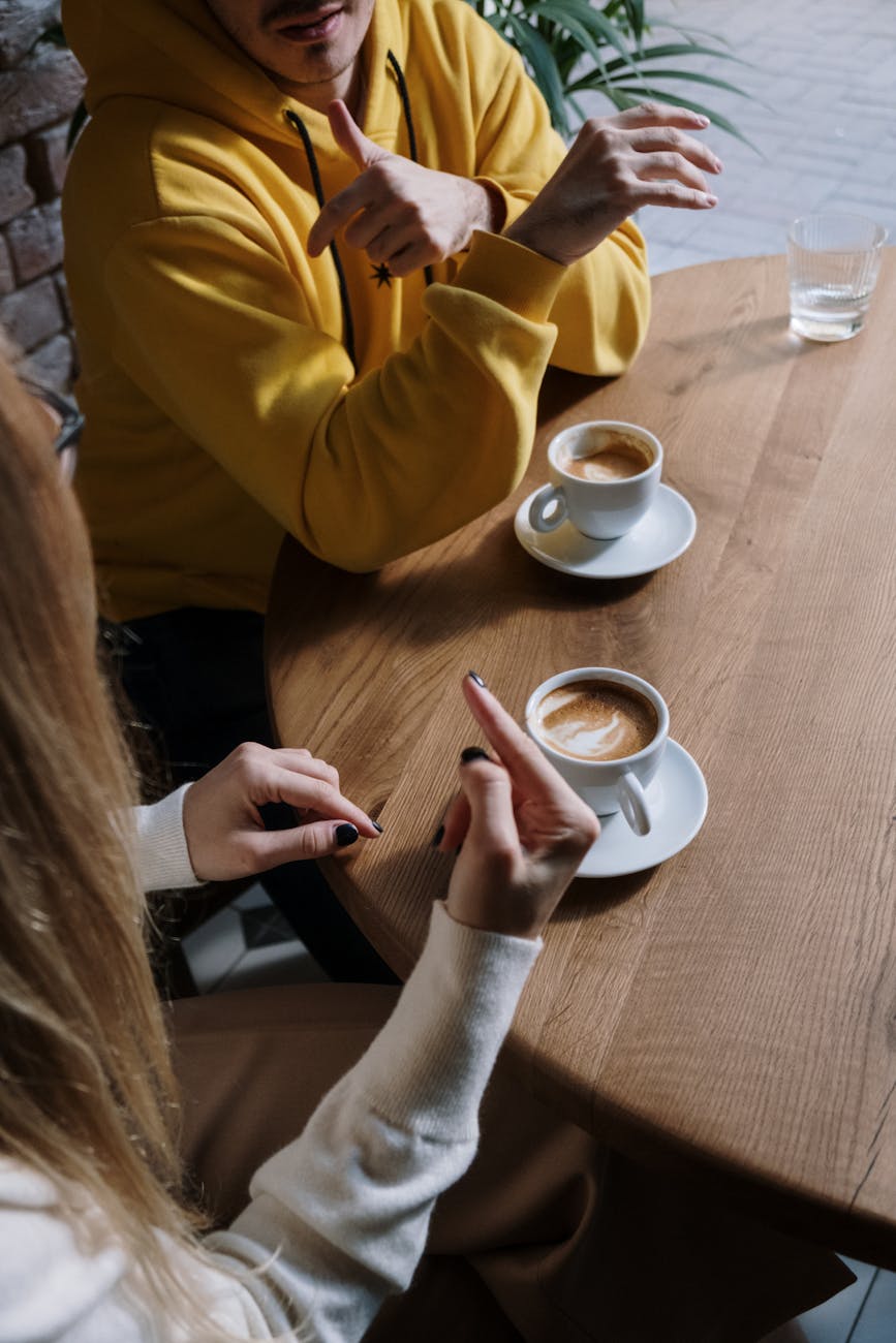 man and woman communicating through hand sign